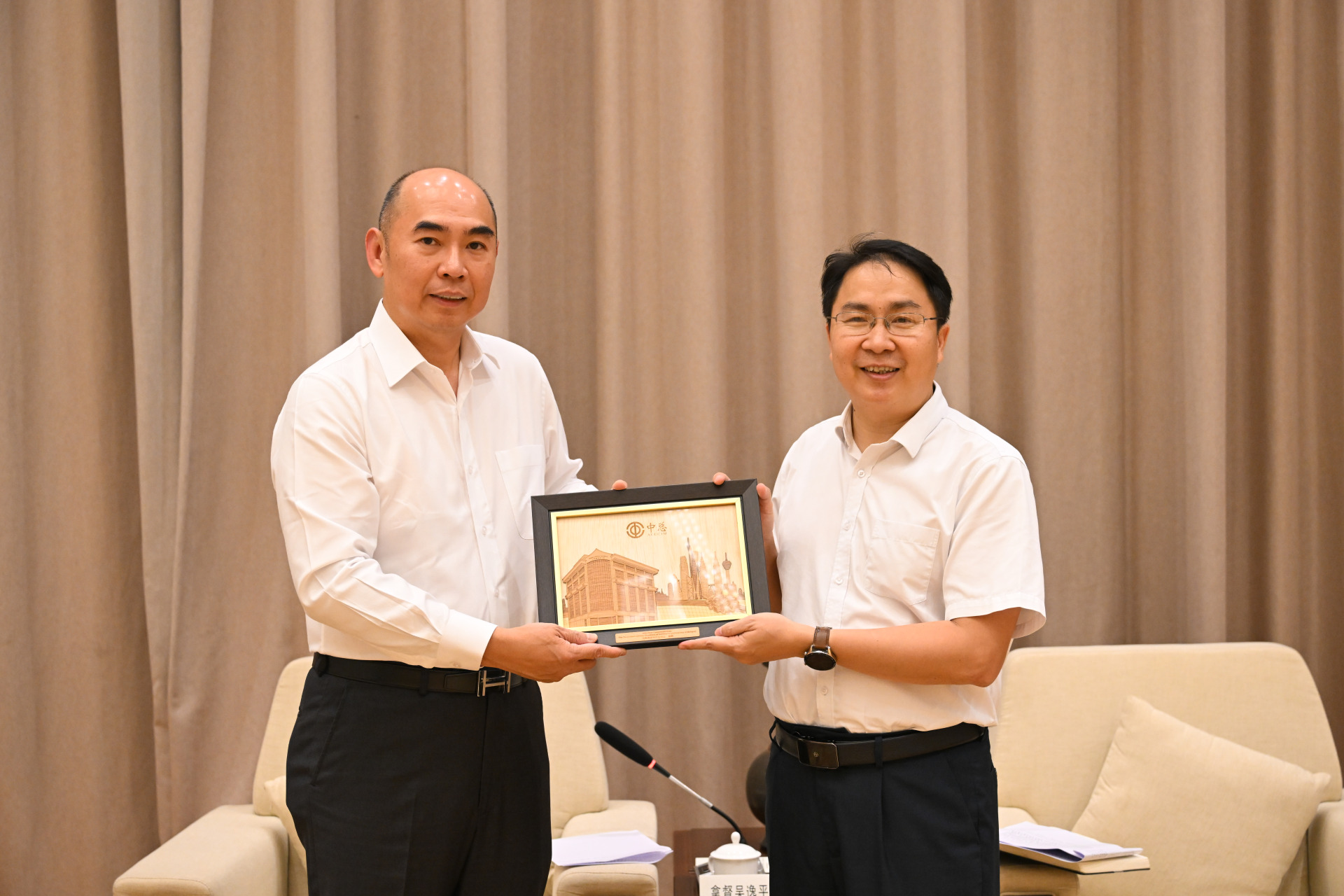 吴逸平(左起)赠送纪念品予李玉成。