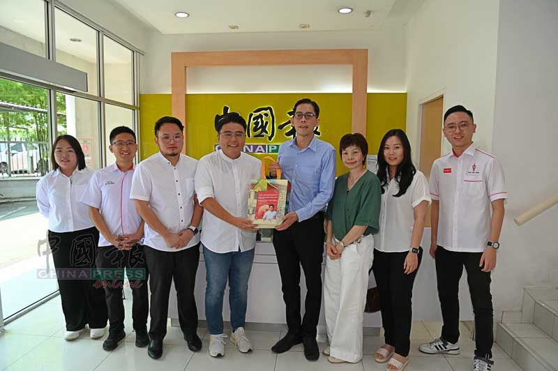 吴家良（左4）向林明标赠送月饼；左起为叶倩莲、何子扬、林骏荣、谭翠凤、叶依雯和许领贤。
