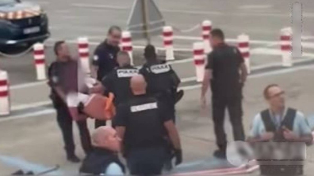 企图打开飞机紧急舱门的醉汉被法国警方抬走。
