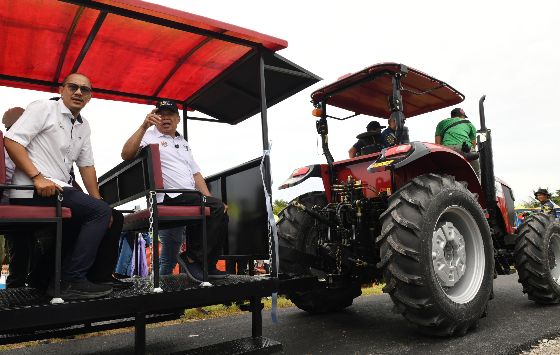 莫哈末沙布(左2)乘坐拖拉车巡视稻田。