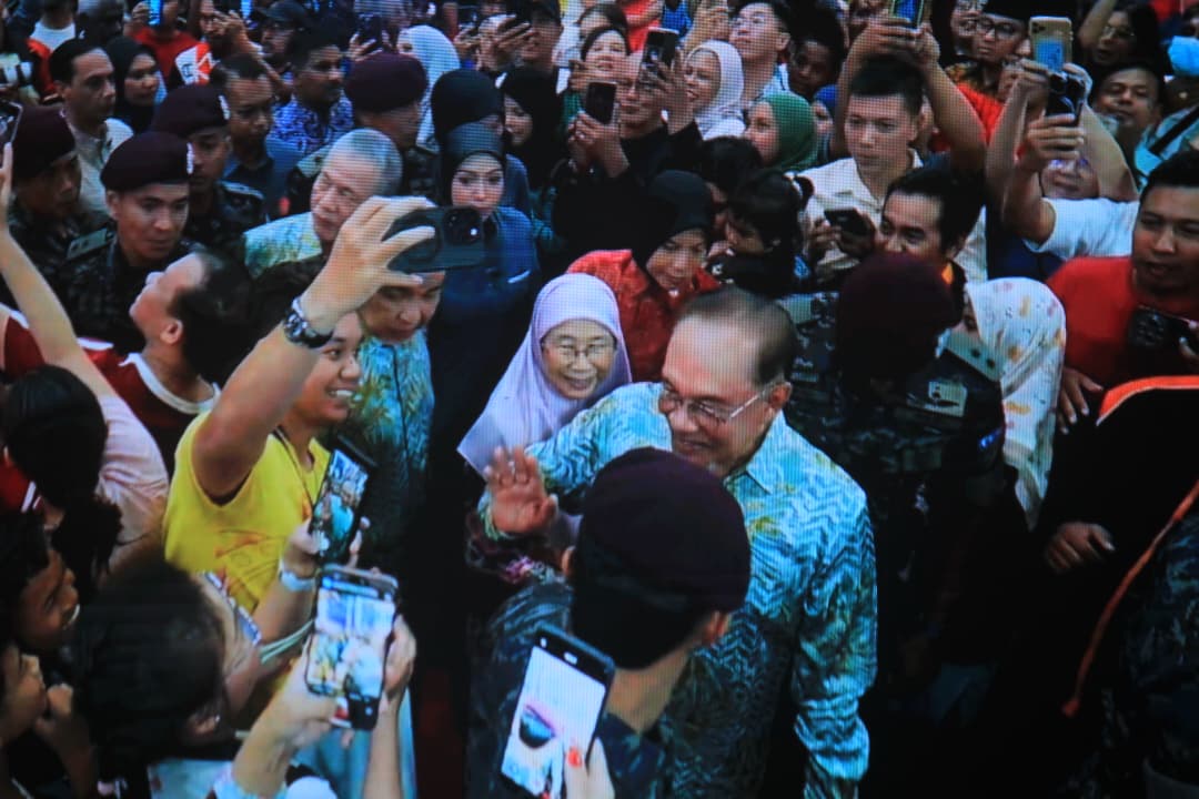 安华伉俪（右起）与热情的民众们打招呼。