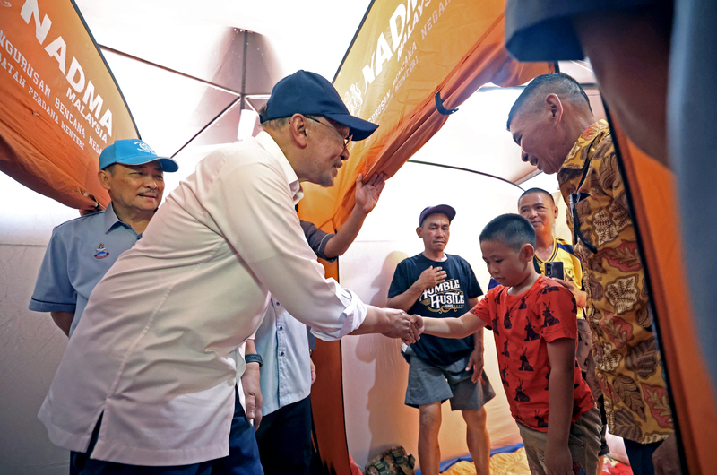 安华慰问疏散中心内的灾民。