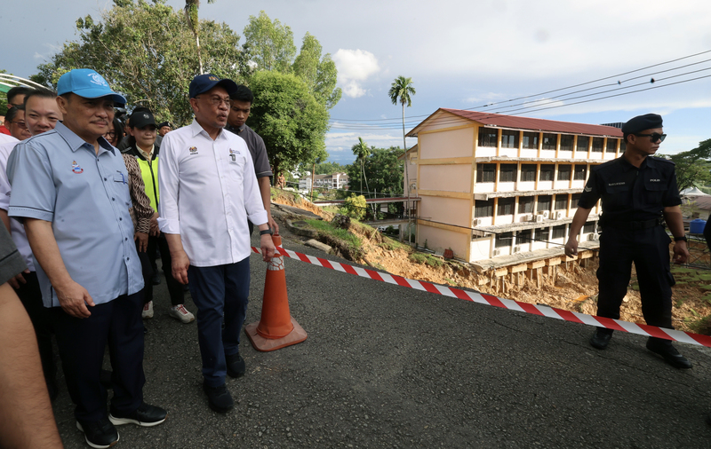 安华（中）在哈芝芝诺（左）陪同下视察加雅师范学院土崩情况。
