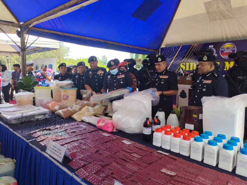 陈胜利（前排左2起）、拉哈曼陪同胡仙检查警方起获的各类毒品。