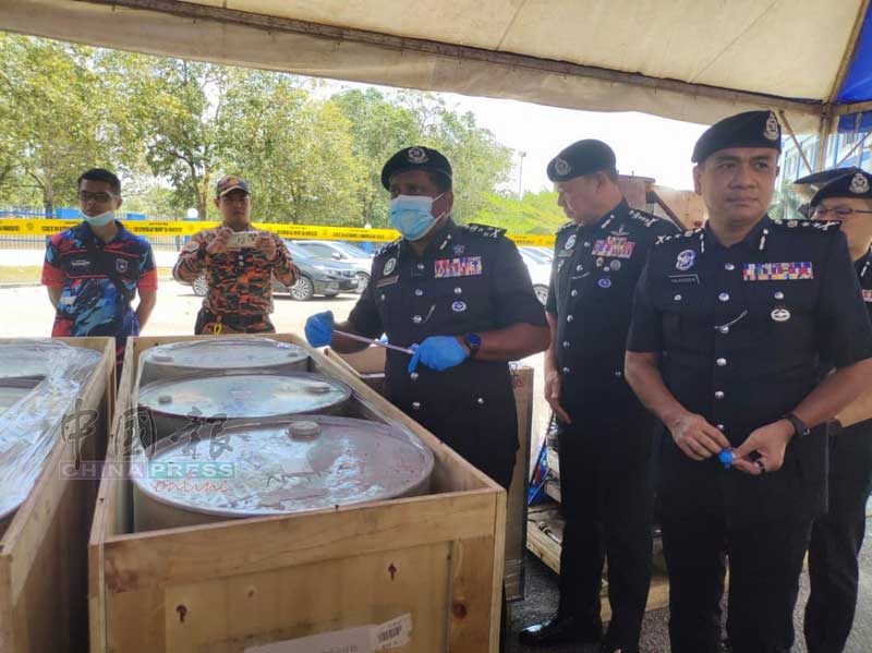 陈胜利（右起）、马沙尼、拉哈曼陪同胡仙视察起获的毒品原料桶。