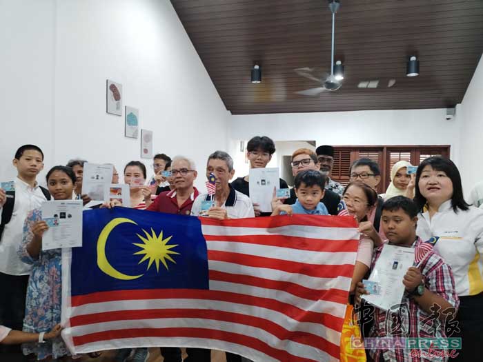 林秀琴（右）祝贺所有获得公民权的人，大家举起国旗一起欢庆国庆日及大马日。