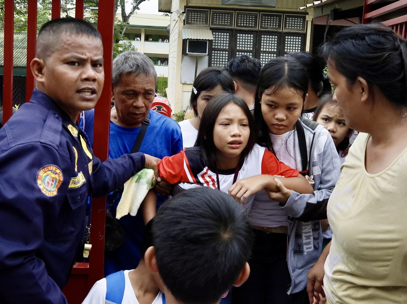 家长和学生撤离学校，有学生害怕哭泣，需要搀扶才能行走。（欧新社）
