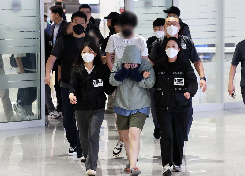 嫌犯在韩国警员的押送下抵达韩国仁川机场。（欧新社）
