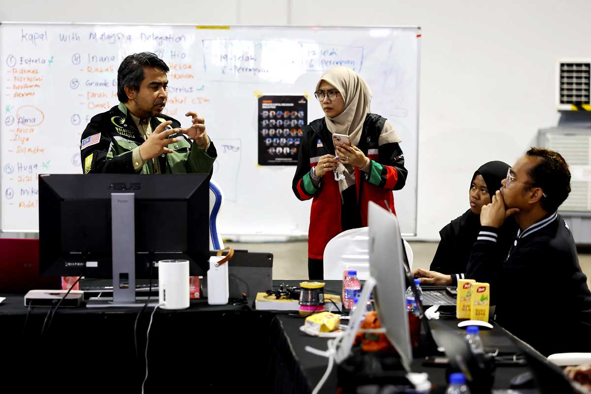 沙尼阿拉比（左）向驻守在苏穆努山塔拉控制中心的官员，猜测参与“全球坚韧船队”大马志工的去向。