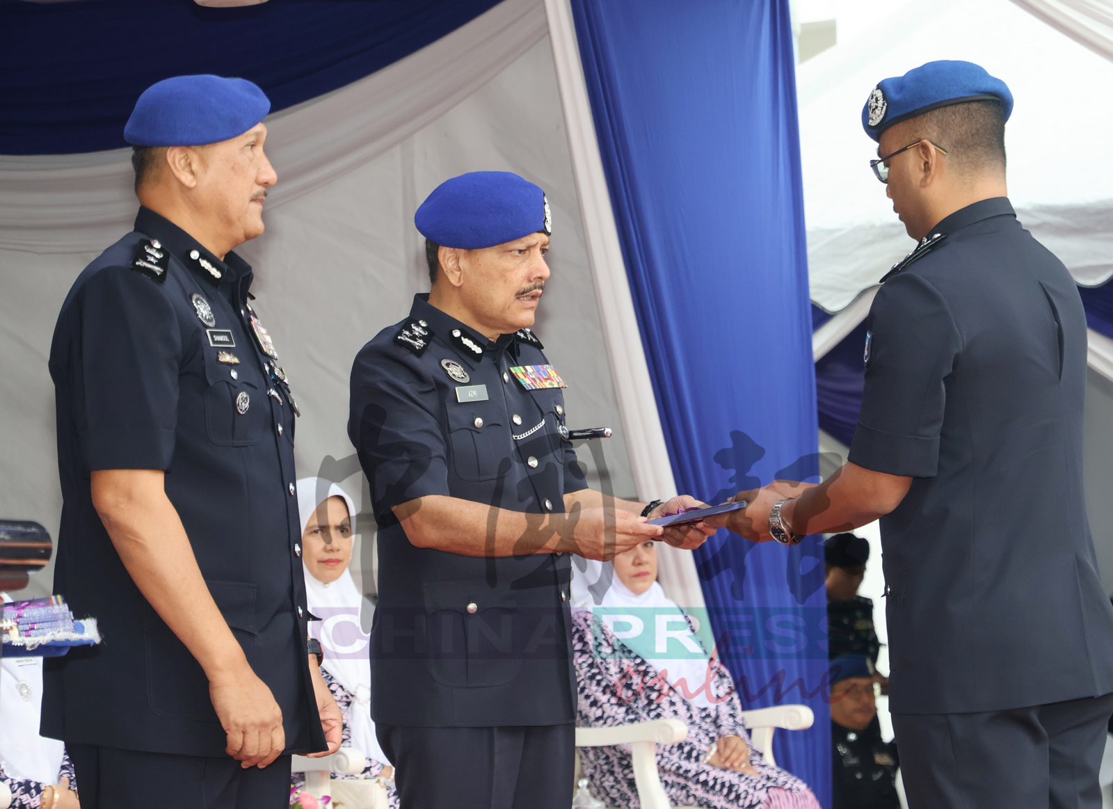 阿兹米（中）颁发褒扬奖予立功警员；左为山苏卡欣。