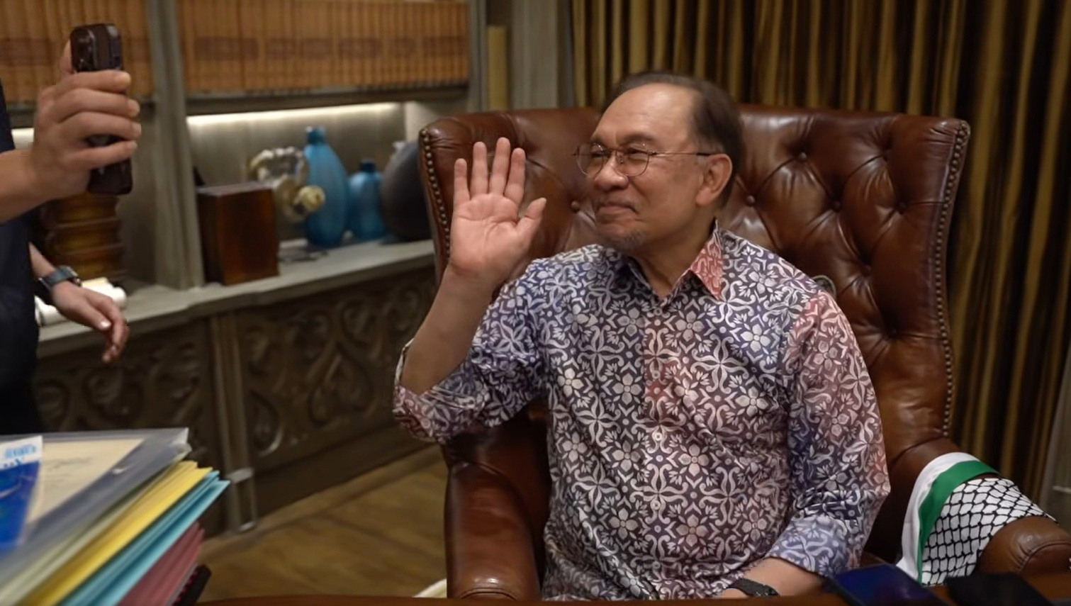 安华在视频通话中向志工们挥手。