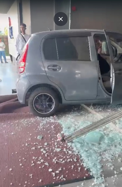 轿车撞破玻璃大门,满地都是碎玻璃。