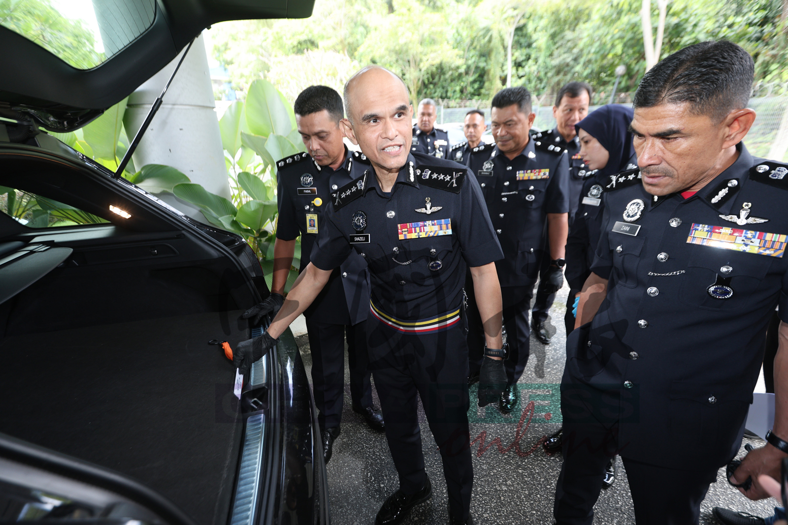 沙兹里（左）说，集团改造马赛地轿车的后车厢暗格，并且必须使用门禁卡才能开启暗格。