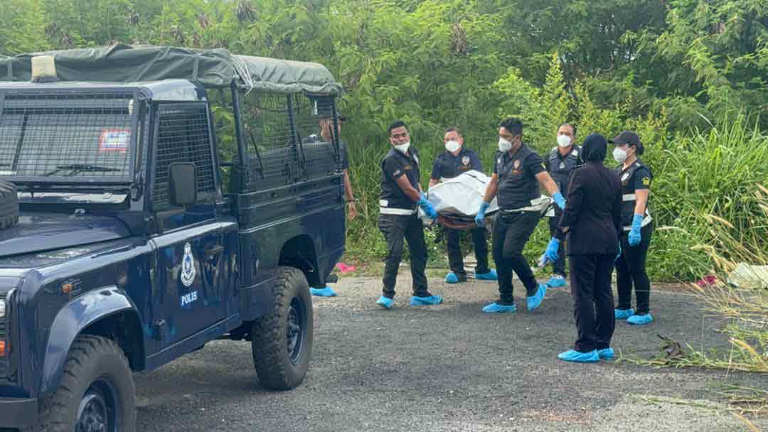 警方把在北海安邦惹惹组屋后方发现的尸体，抬上黑车。