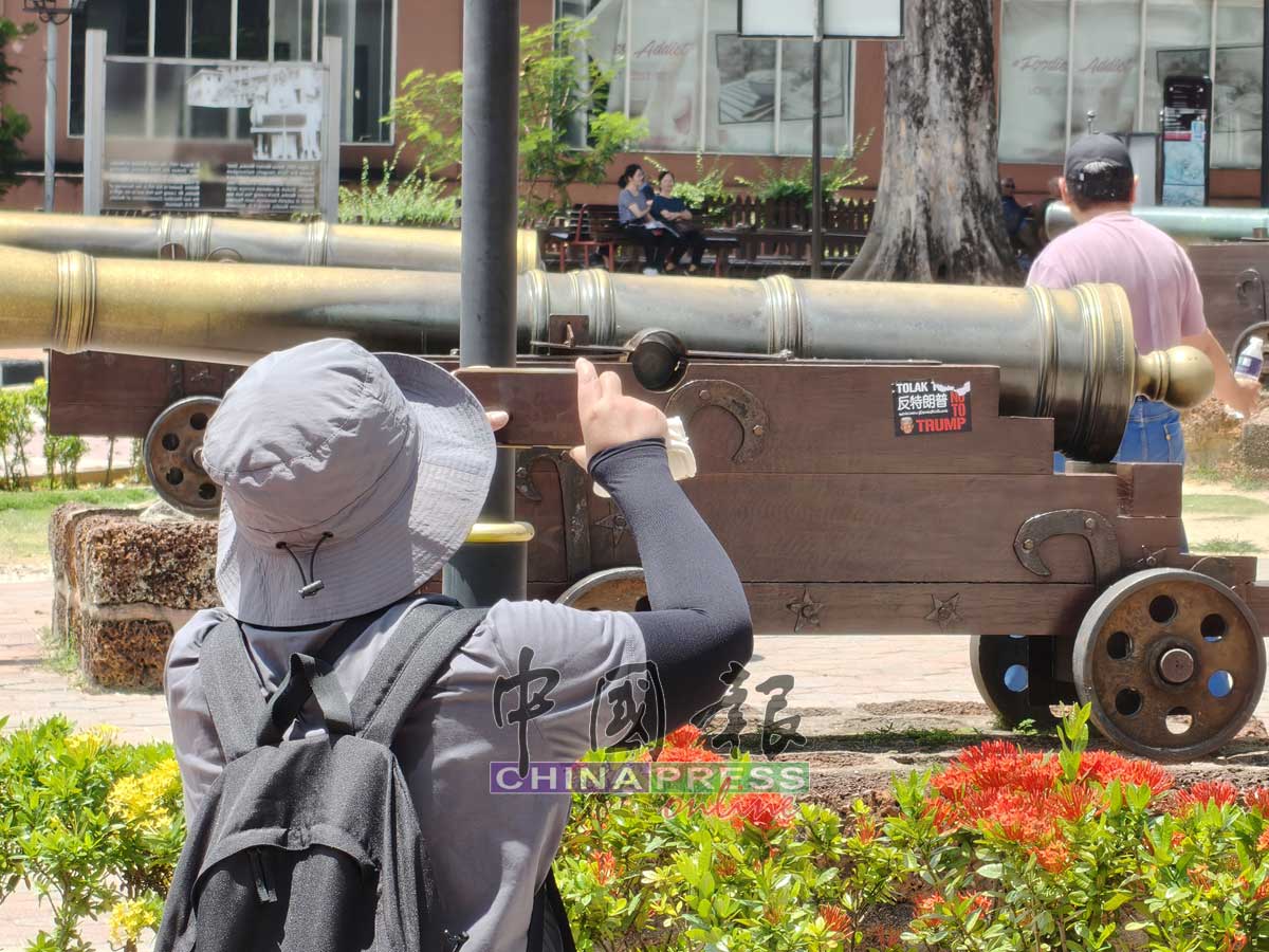 贴在大炮处得反特朗普贴纸吸引游客拍照。