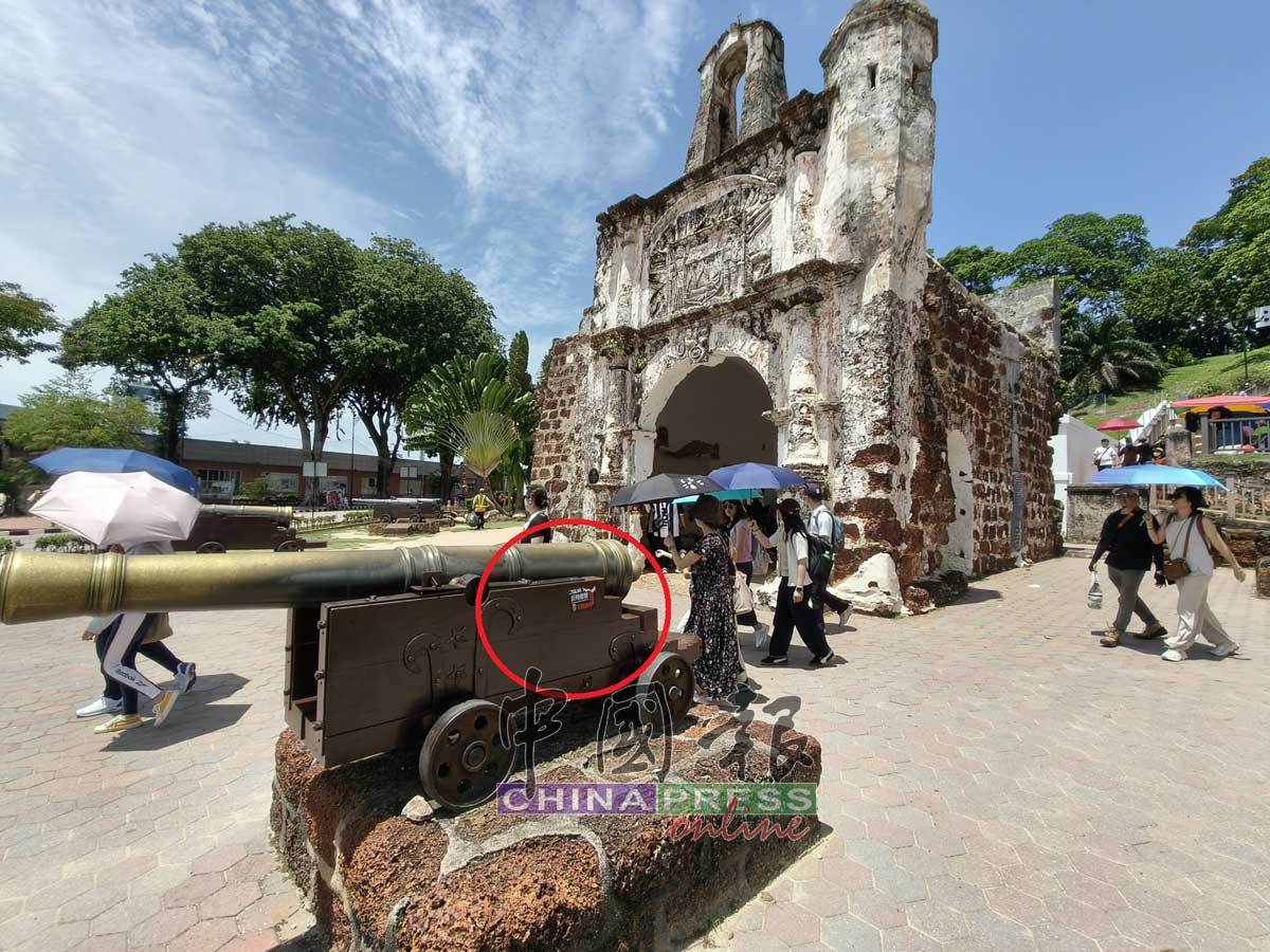 “反特朗普”贴纸出现在古城门前得大炮上，突显在百年古迹背景中格外显眼。