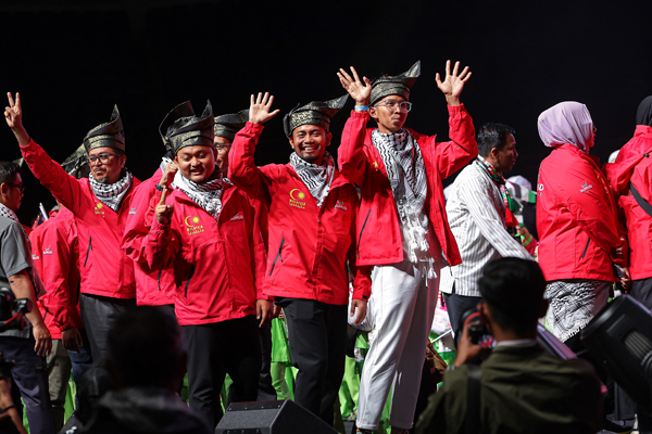 早前遭以色列扣留的大马志工，在大会上手挥示意。（马新社）