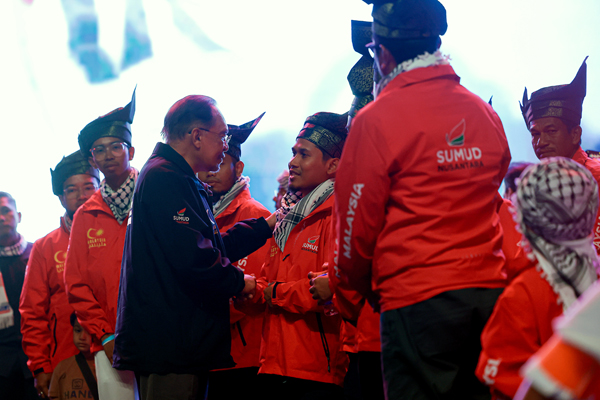 安华（左）慰问大马志工。（马新社）