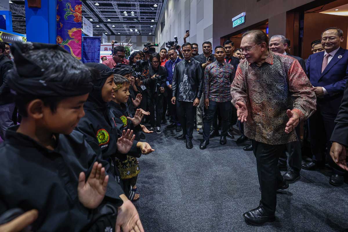 安华（右）与表演马来武术的小朋友们亲切交流。