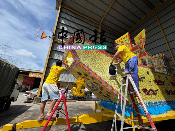 李成安（右起）和李成良为皇船进行最后的工作。