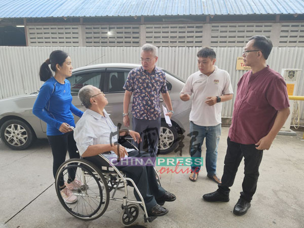 邱培栋(站者左2)为沈渊全(坐轮椅者)带来好消息,右是刘志俍。