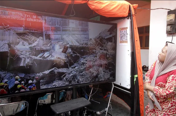 受困者的家属透过大屏幕留意搜救行动最新情况。