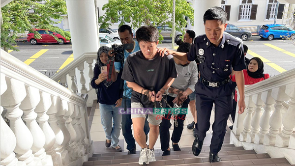 华裔青年（左）被庭警扣押到乔治市地庭面控。