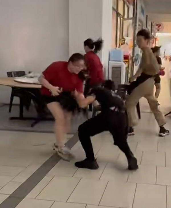 男子差点被风吹走，女子上前拉住才避免了意外。