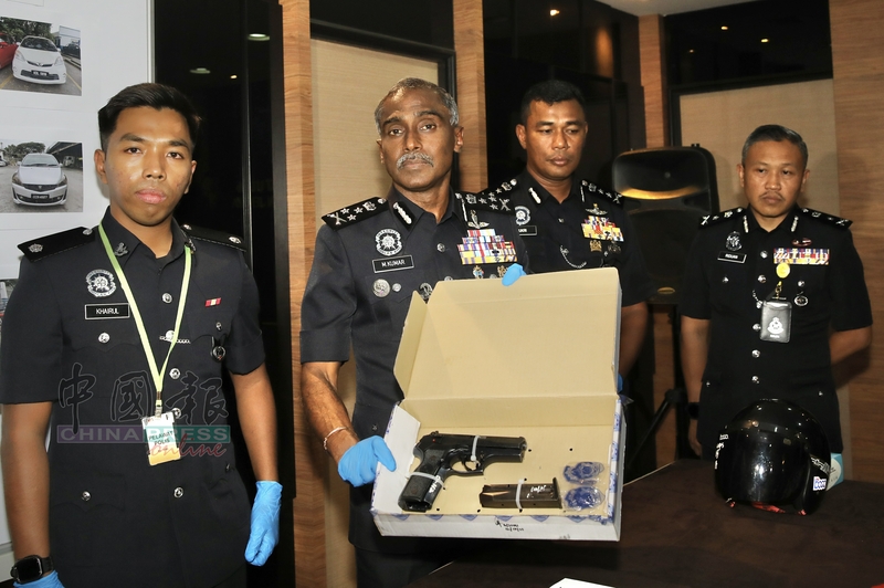M古马（左2）向记者展示，警方在行动中，起获的自动手枪。
