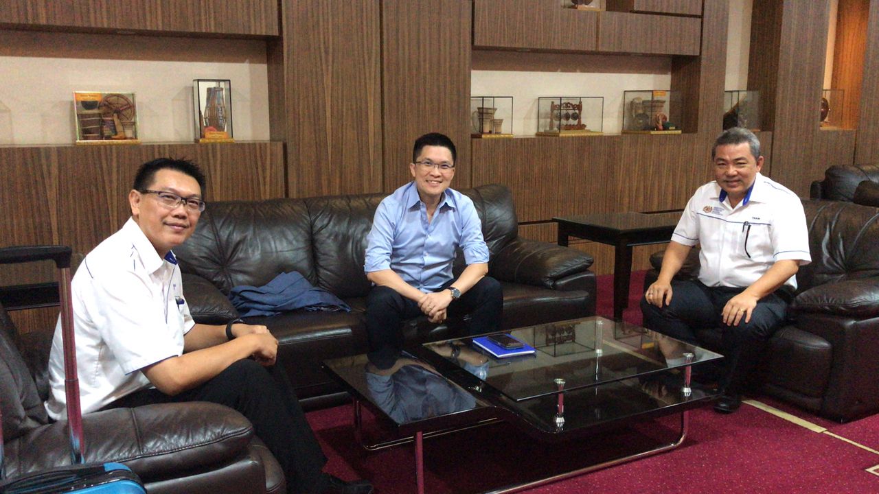 谭永福（右）也与教育部副部长黄家和（中）交流州教育方针。
