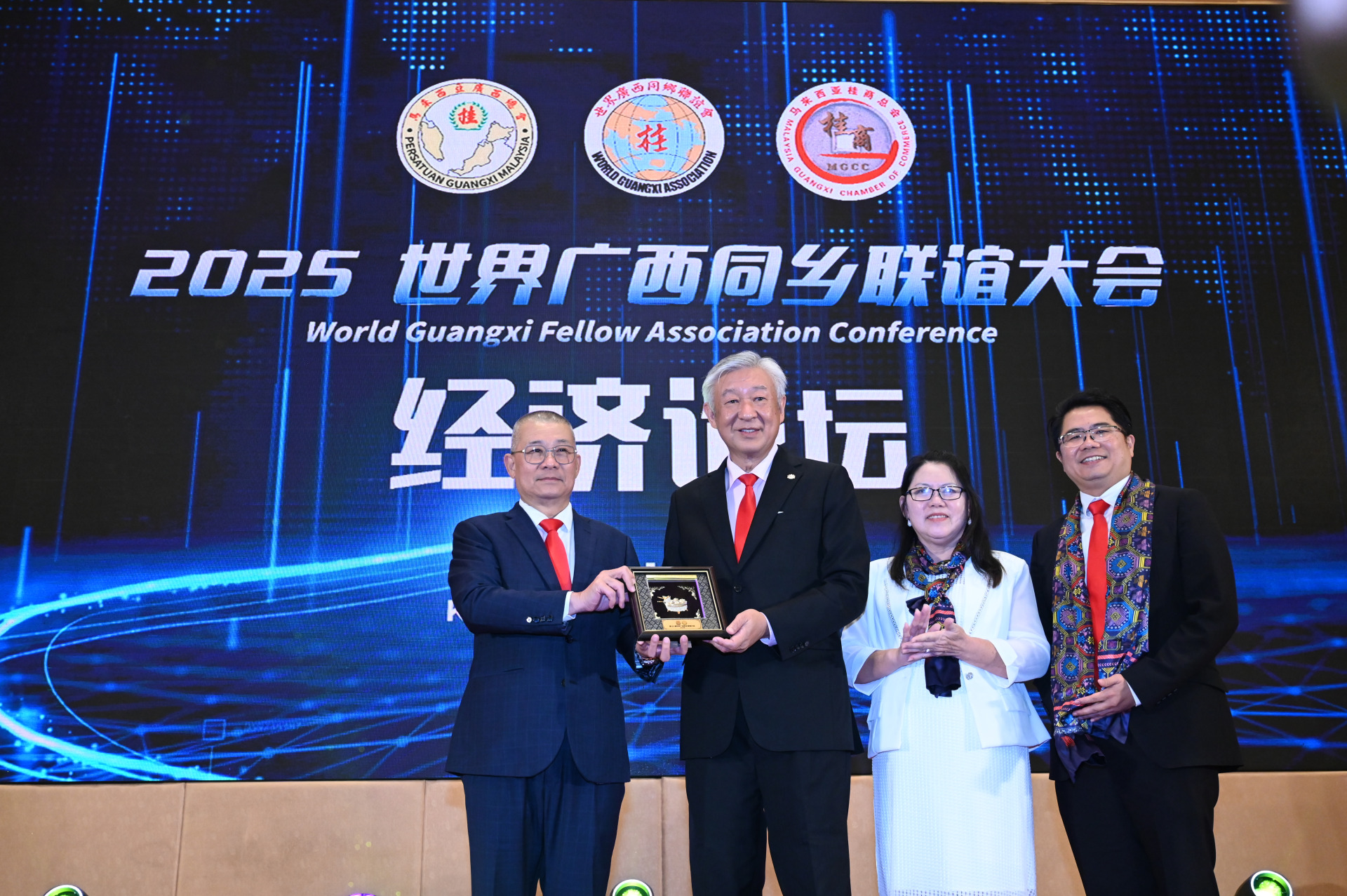 吕海庭（左）移交纪念品予卢成全（左2），由梁小琴与吴岳峰见证。