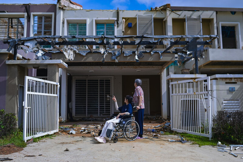 天然气输送管爆炸事故后，2名布特拉高原居民返回灾区，无语的看着损毁的屋子。
