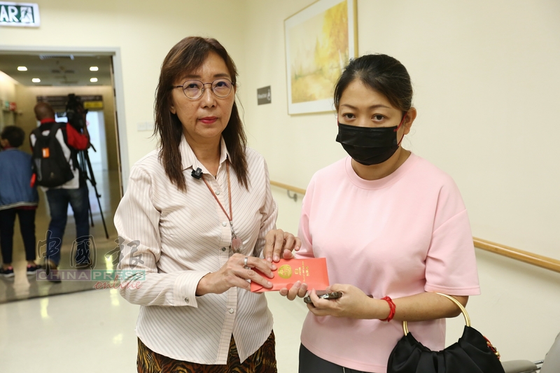 郭素沁（左）拨款1万令吉予陈思慧家人，由赖瑞玲（右）领款。