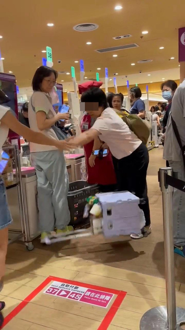 穿粉色上衣的乡音大妈目露凶光，把港女的“买菜车”一手抬高，再翻倒掉在地上，令内里货物散落一地。