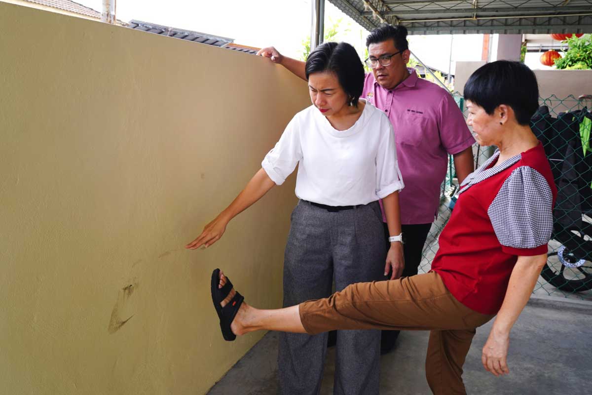 匪徒在翻墙逃离时留下脚印。右起为邱嘉丽、黄伟良、王丽丽。