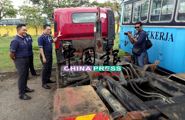 阿兹林（左2）展示被拍卖的其中一辆卡车罗厘。