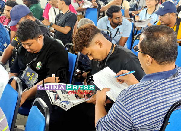 民众翻阅拍卖目录，盘算出价策略。