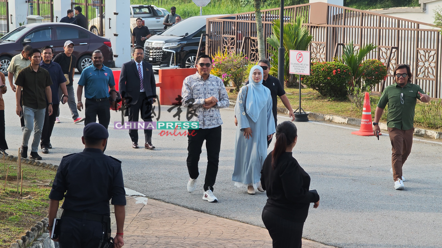 阿克马（中）在妻子陪伴及支持者跟随下抵达大山脚推事庭。