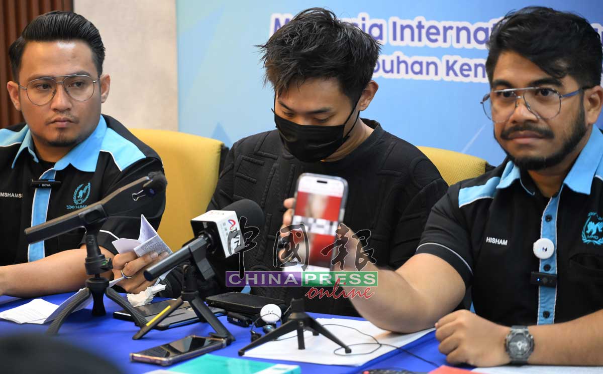 希山慕丁（右1）在记者会上，播放被迫拍的赤裸视频。