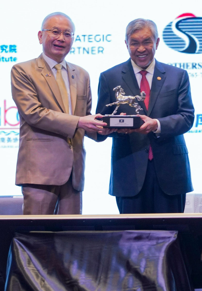 魏家祥（左）赠送阿末扎希纪念品。