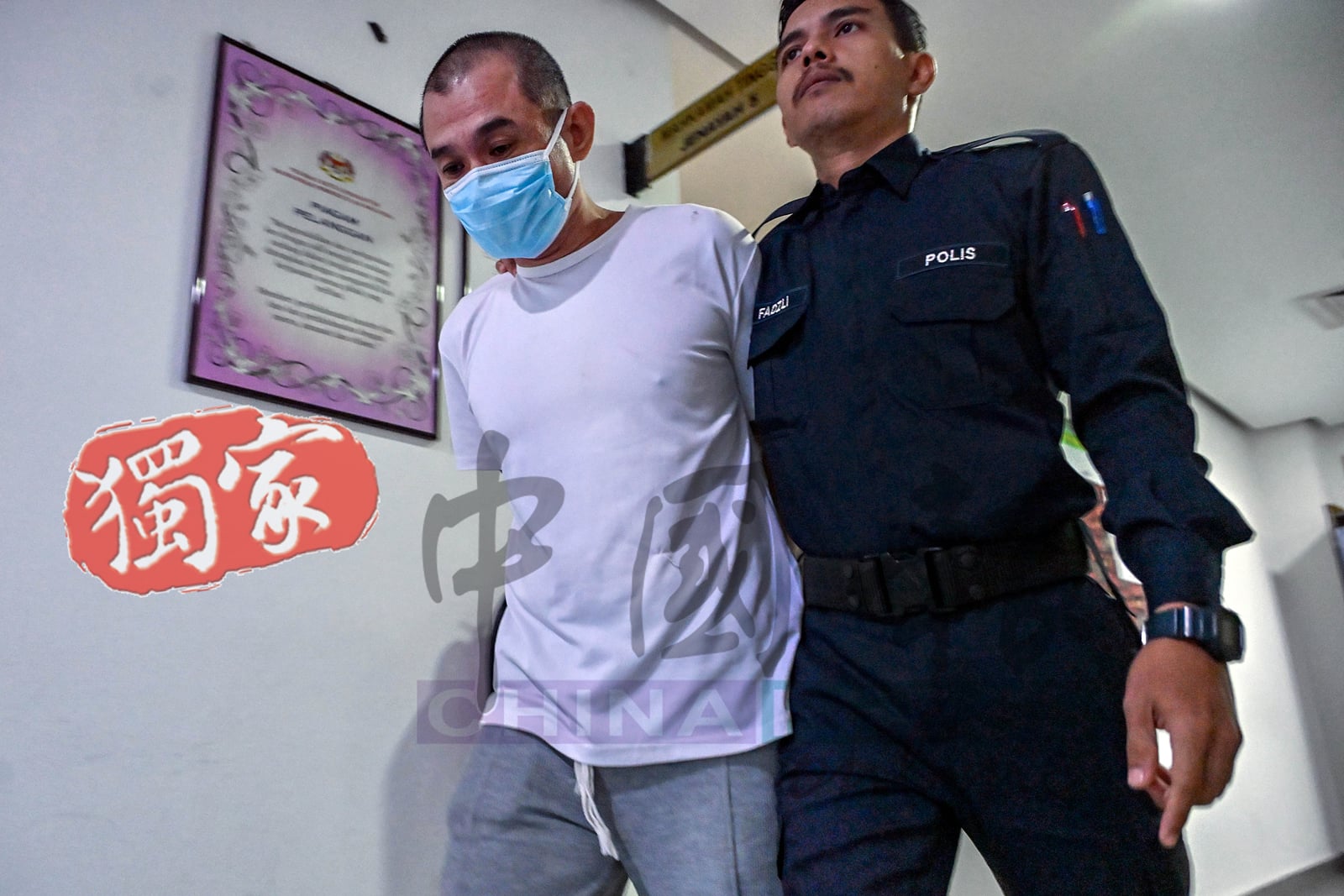 现年46岁的江昌兴（左）遭判刑后，被庭警押离法庭。