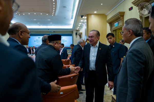 安华(右2)与出席会议者握手交流。