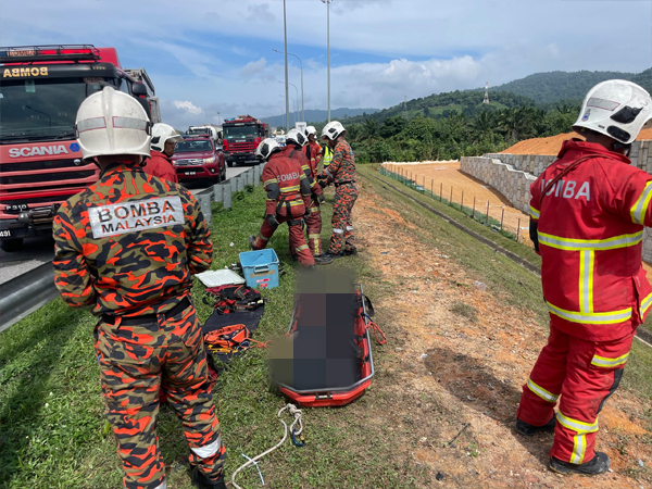 消拯员把司机的遗体移上路肩。
