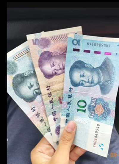 马来顾客展示中国男子支付的25元人民币钞票。