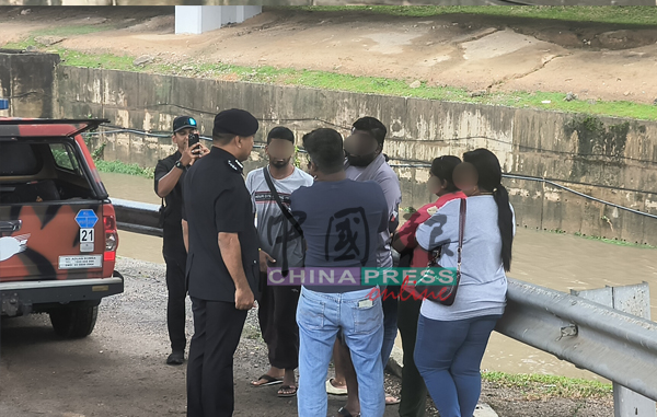 沙扎里(左)向失踪者家属了解情况。