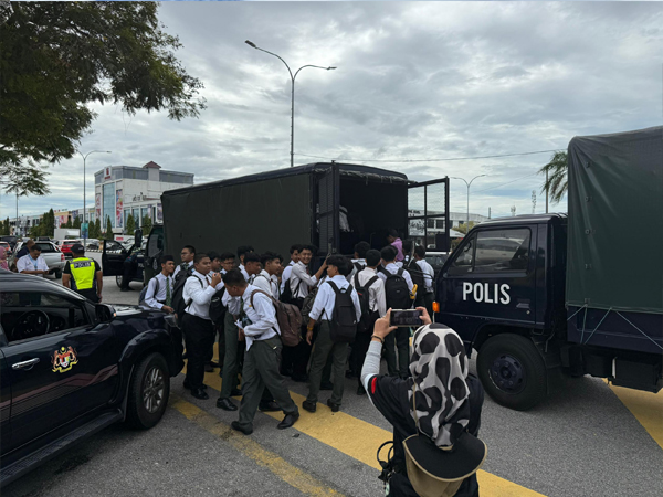 警方出动卡车，将日得拉国中的SPM考生转移至其他考场。

