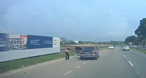 女子跳车后，自行站起身准备逃跑。
