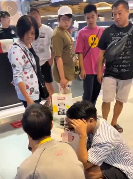 店员松开锁喉后，白衣男在众人的围观下并未逃离现场，仅是掩面蹲在原地。