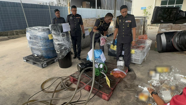 杰根（右2）示范不法之徒如何利用特制工具，把食用油重新分装至印有特定品牌的5公斤空桶。