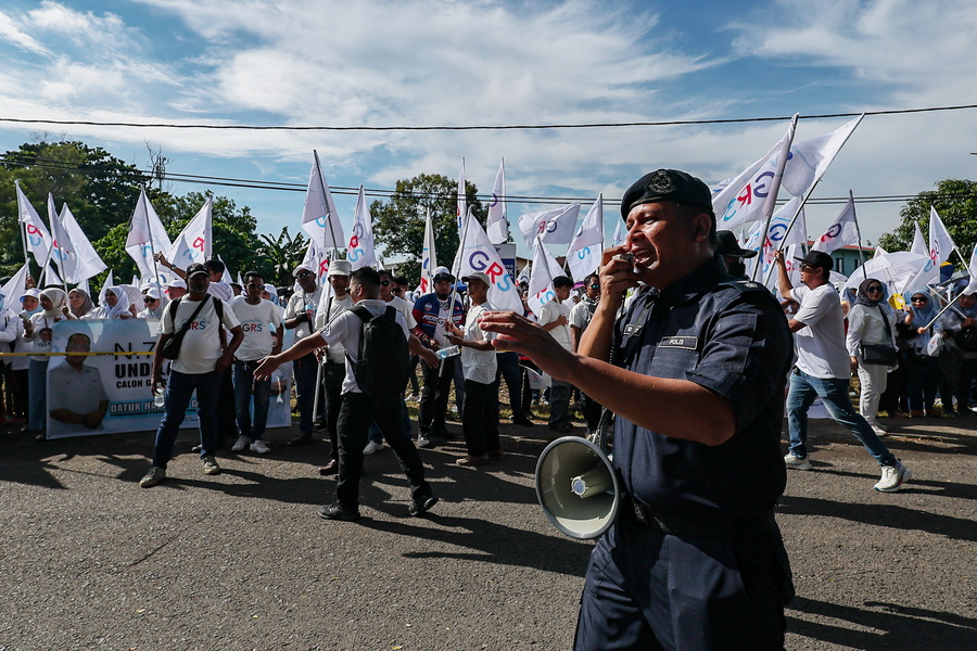 警员使用广播器呼吁支持者维持秩序，不要擅自闯入封锁线。
